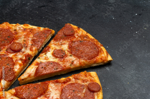 Italian pizza pepperoni on dark stone background