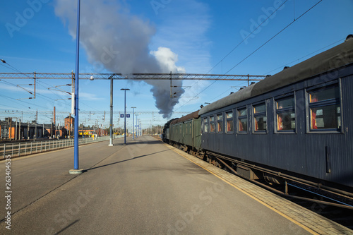 Kouvola, Finland - April 18, 2019: Old steam train Ukko-Pekka is leaving the station at morning. photo