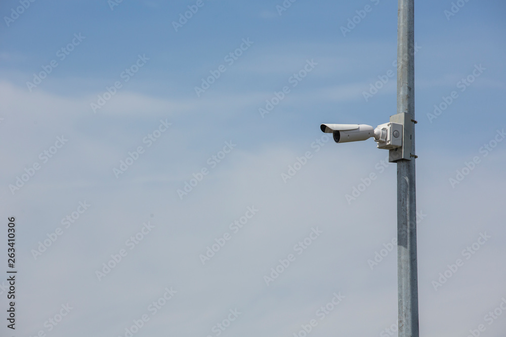 CCTV security cameras on pole on blue sky with white clouds background Limited depth of field.