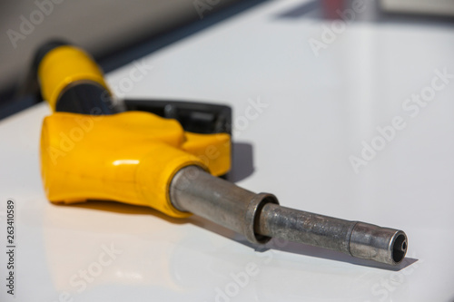 Gasoline pistol pump fuel nozzle Gas station pump. Man refueling gasoline with fuel in a car, holding a nozzle. Limited depth of field.
