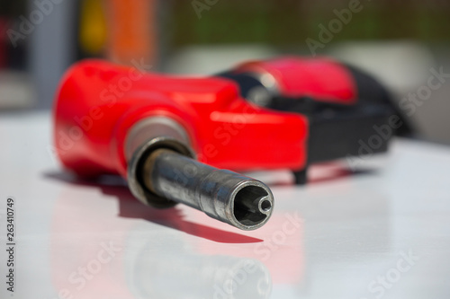 Gasoline pistol pump fuel nozzle Gas station pump. Man refueling gasoline with fuel in a car, holding a nozzle. Limited depth of field.