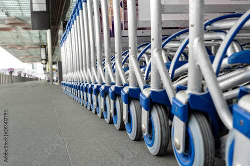 Trolleys luggage in a row in modern airport. Close up of luggage carts