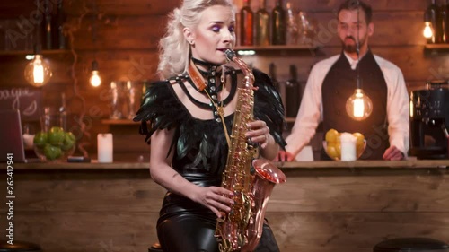 Wallpaper Mural Woman performs on a saxophone in front of a bar counter. Concert in a small restaurant. Female musician plays on a sax. Torontodigital.ca