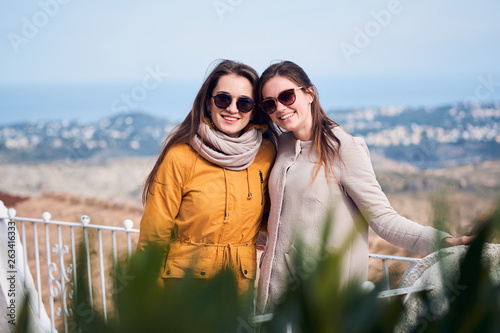 Two cute female friends smiling and looking into the camera photo