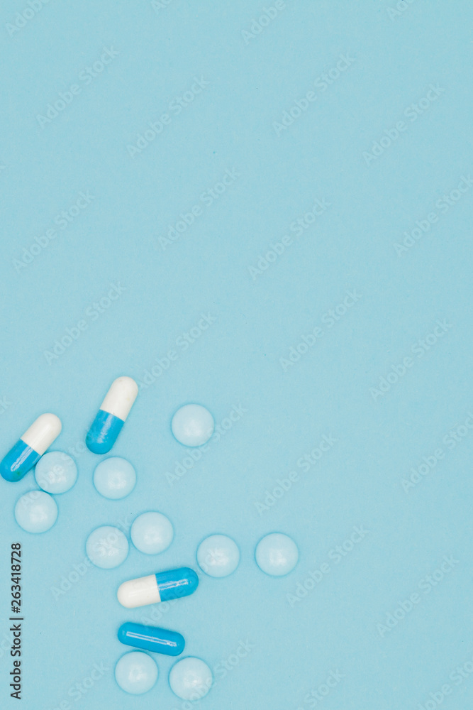 Scattered blue pills on blue table. Mock up for special offers as advertising, web background or other ideas. Medical, pharmacy and healthcare concept. Copy space. Empty place for text or logo