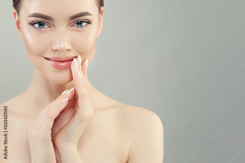 Young beautiful female face. Young woman with healthy skin and manicured nails portrait