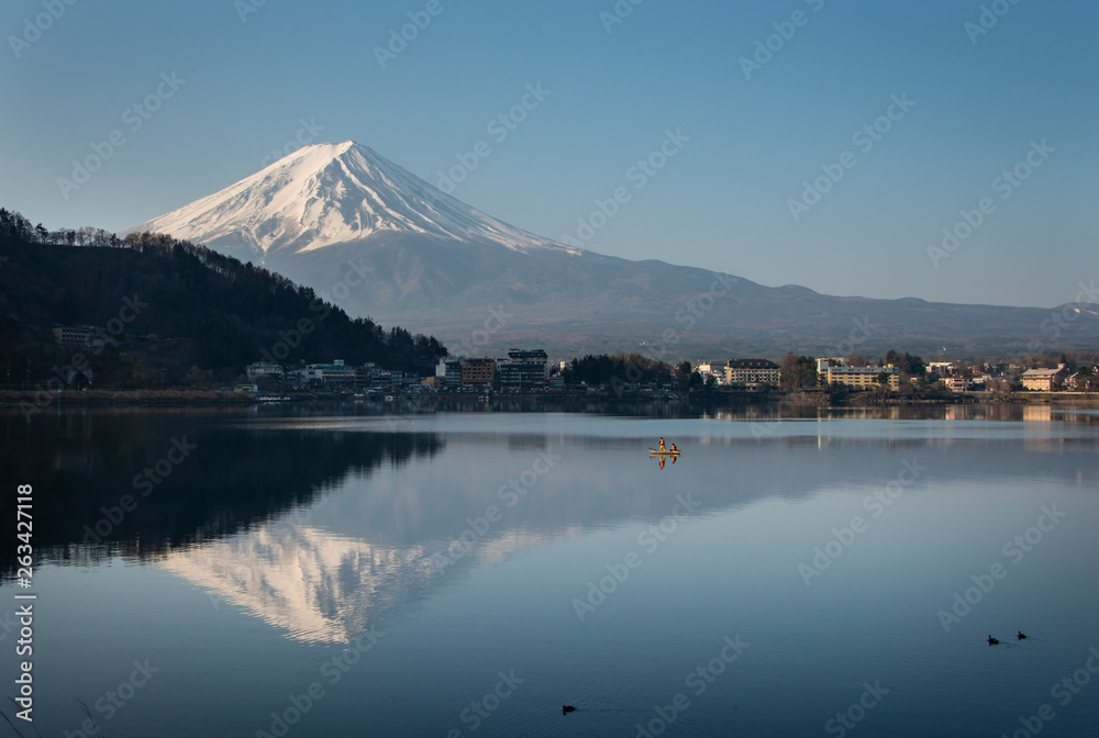 Magnificent Mt Fuji reflected in the lake Kawaguchiko with fishermen out fishing on the lake