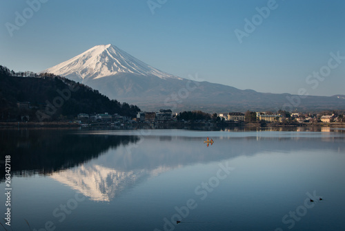 Magnificent Mt Fuji reflected in the lake Kawaguchiko with fishermen out fishing on the lake