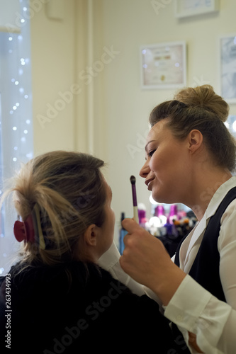 Makeup artist working with the client.Talking and smiling.. Professional make-up. Work in the beauty industry. Style selection.