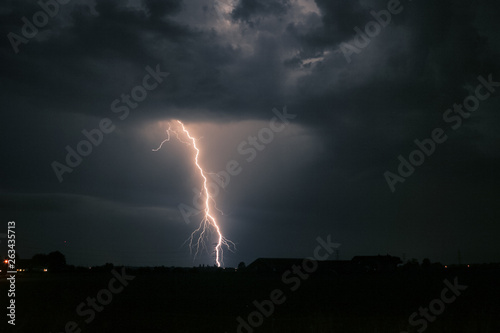 Bright branched lightning strike near an electricity mast from a severe thunderstorm in The Netherlands