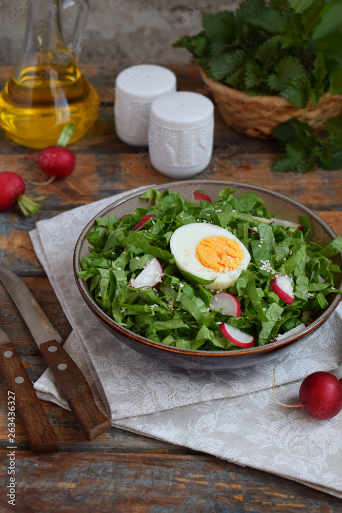 Vitamin salad from lettuce, radish, green onions and eggs, seasoned with vegetable oil in plate on wooden background. Healthy food. Salad of fresh green vegetables Vitamin salad from lettuce, radish, green onions and eggs, seasoned with vegetable oil in plate on wooden background. Healthy food. Salad of fresh green vegetables