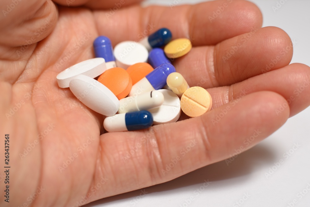Various medical pills and capsules picked up with hand Various medical pills and capsules picked up with hand
