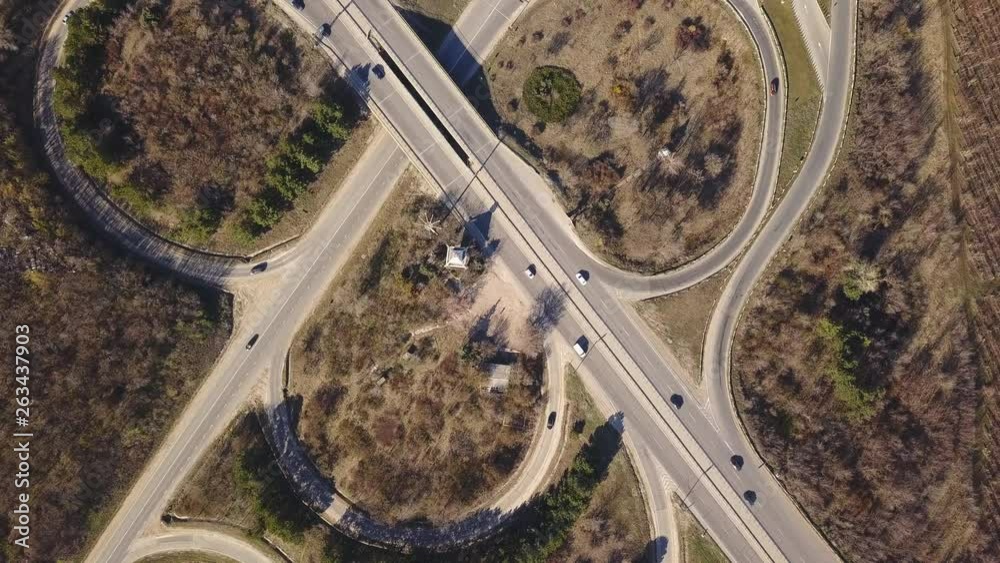 Aerial top down view of interchange road junction traffic. Drone shot flying over crossing roads and railway track. Moldova republic of. Aerial top down view of interchange road junction traffic. Drone shot flying over crossing roads and railway track. Moldova republic of.