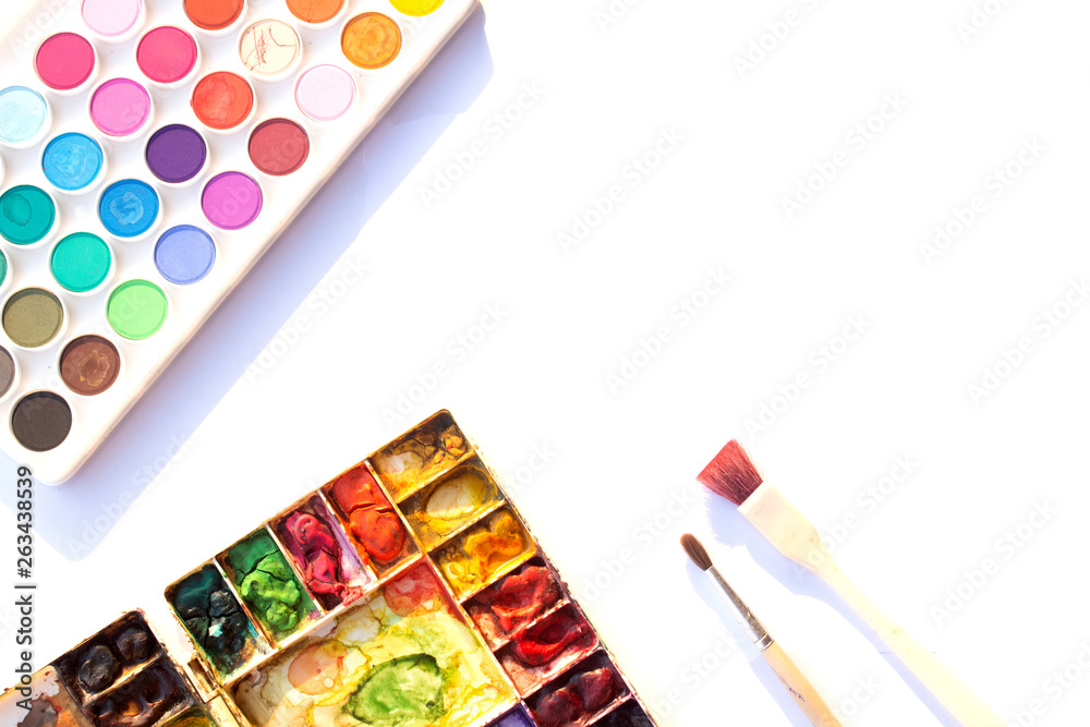 Plate for mixing watercolors filled with many colors of dry paint. Watercolor  tray and brush on white background. Stock Photo