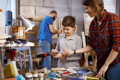 Schilderij op canvas Parents and son tinkering together