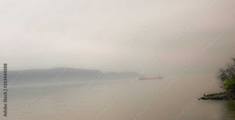 barge on the hudson river in fog and morning mist