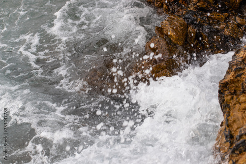 The ocean waves hit the rocks on the rocky beach in the morning, Ocean waves hit the rocks at the beach.