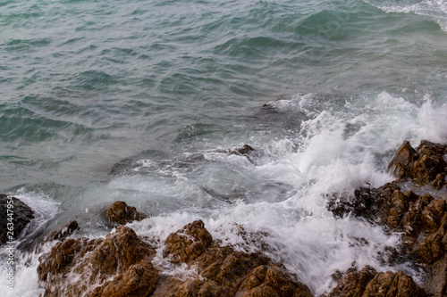 The ocean waves hit the rocks on the rocky beach in the morning, Ocean waves hit the rocks at the beach.