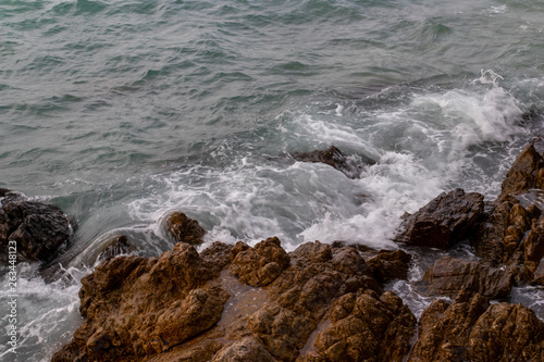 The ocean waves hit the rocks on the rocky beach in the morning, Ocean waves hit the rocks at the beach. © Nui