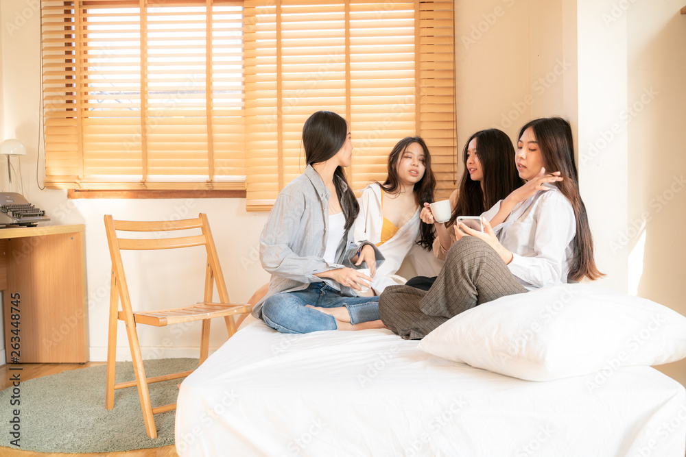 Fashion beautiful asian women group talking together on bed in room Fashion beautiful asian women group talking together on bed in room