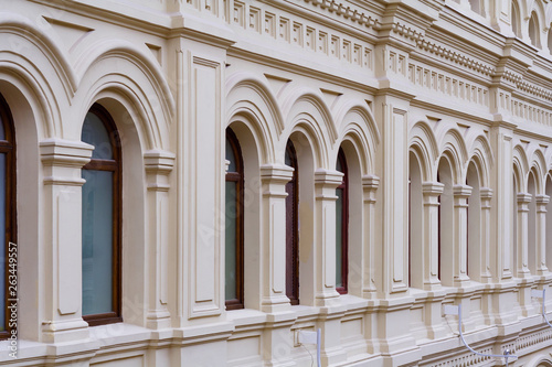 Perspective view on a facade of ancient stone building with decorative ornaments and windows