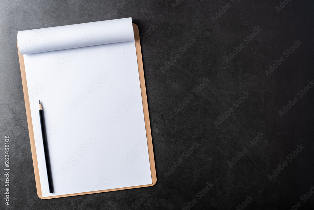 white paper with clipboard on black stone background white paper with clipboard on black stone background