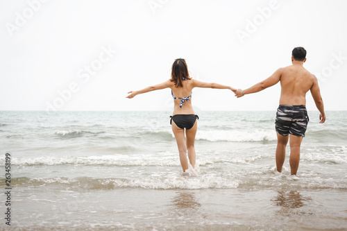 Asian couple relax on beach