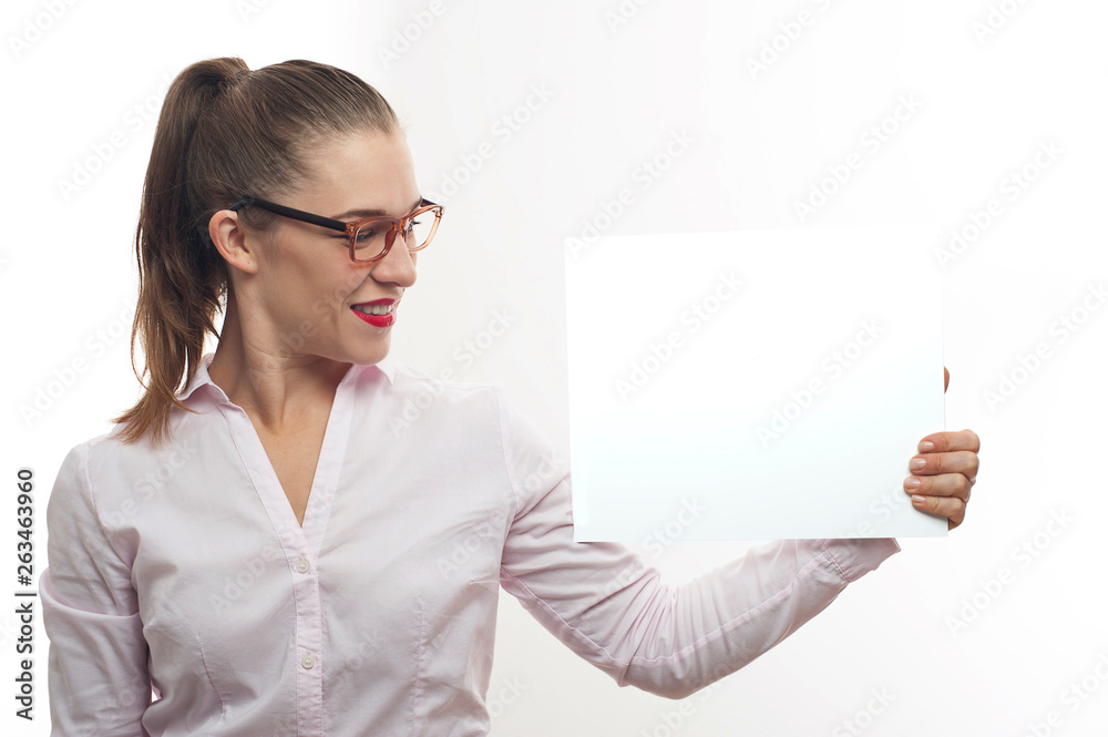 Young woman in eyeglasses point at white banner Young woman in eyeglasses point at white banner