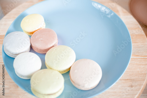Kitchen plate with colorful macaroon. Wooden table