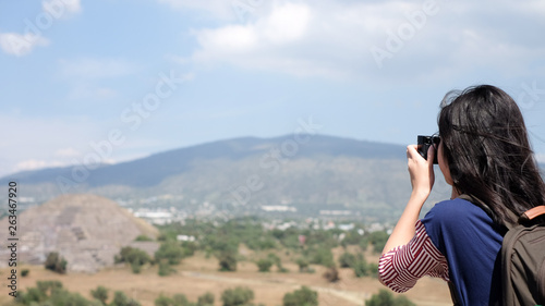 Asian girl taking photo of pyramid in mexico