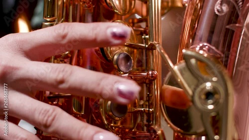 Female playing on a beautiful saxophone. Performing on a wind musical instrument.