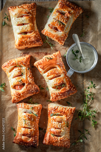 Fresh sausage in puff pastry with tatar sauce and herbs