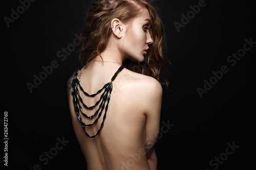 beautiful woman with necklace on her naked back