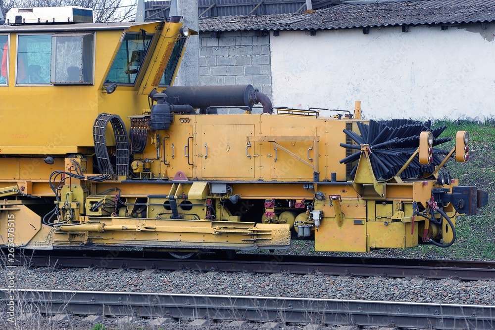 yellow repair locomotive stands on the rails of the railway