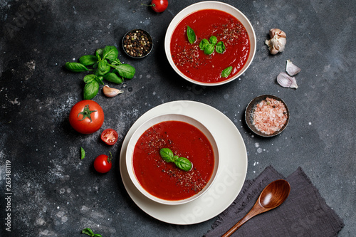 Traditional Spanish cold tomato soup gazpacho in a white bowl on a dark stone background. Traditional Spanish food. Concept of Spanish cold soup made of ripe tomatoes. Copy space, top view soup.