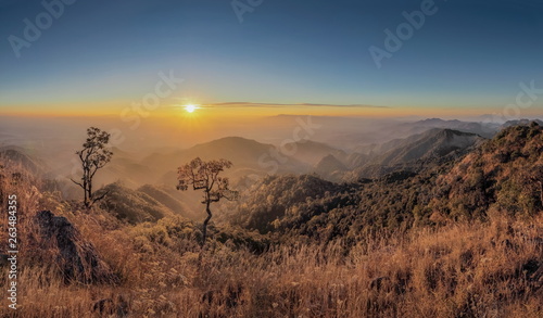 Mountain view misty morning of top hills around with the soft fog with yellow sun light in the sky background  sunrise at top of Doi Ang Khang  Chiang Mai  northern of Thailand.