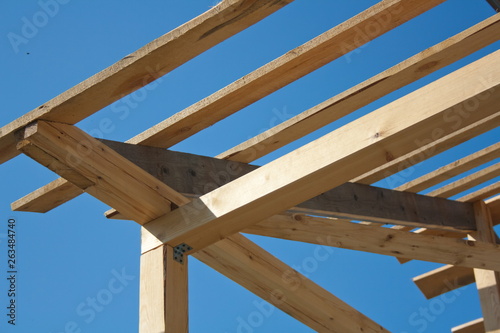 the wooden frame of the roof against the sky