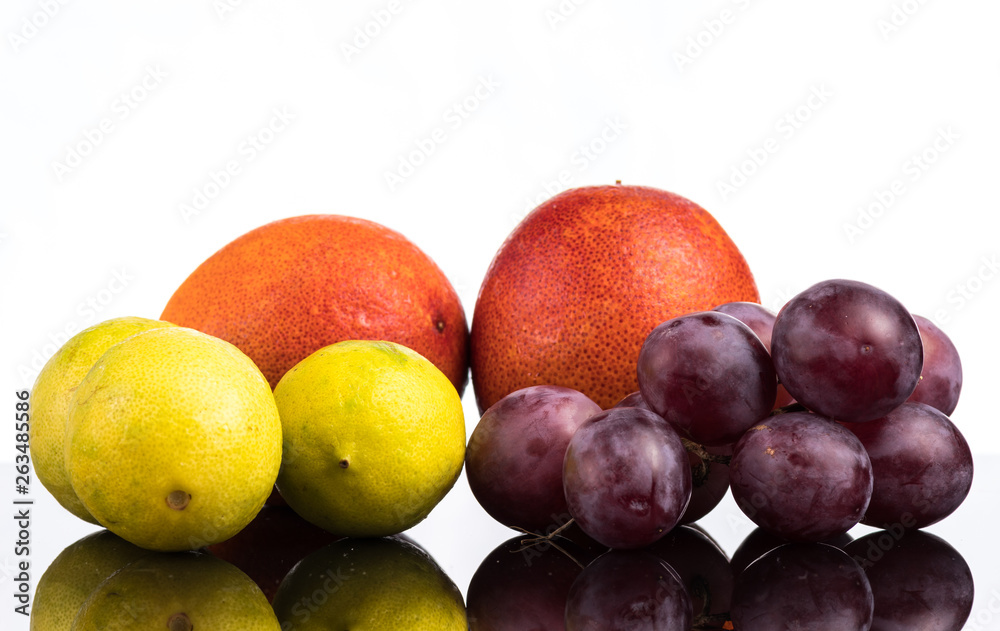Bloody orange, lime and grapes close up close up with reflection on white and black background Bloody orange, lime and grapes close up close up with reflection on white and black background