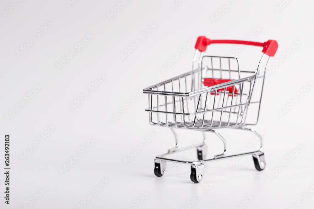 Grocery cart close up. The cart under products standing on a white background. Empty grocery cart on white background  with copy space.