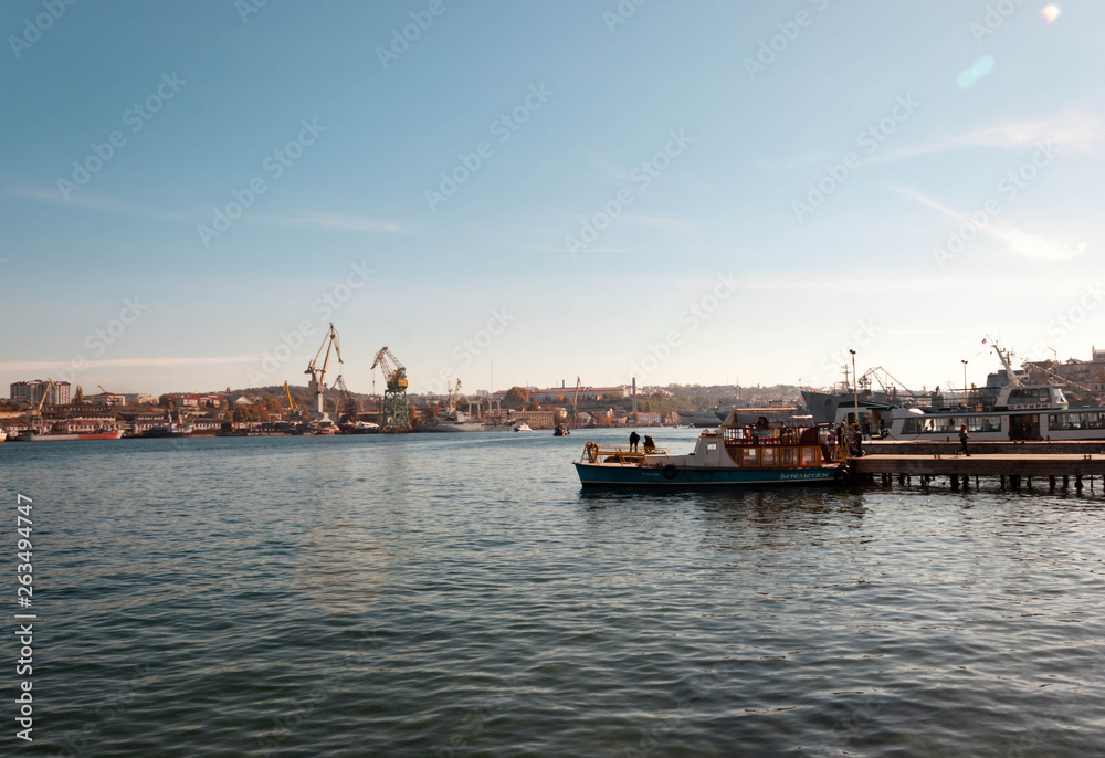 SEBASTOPOL, RUSSIA - NOVEMBER 4,2018: view of the port with cranes and fishermen fishing on a boat