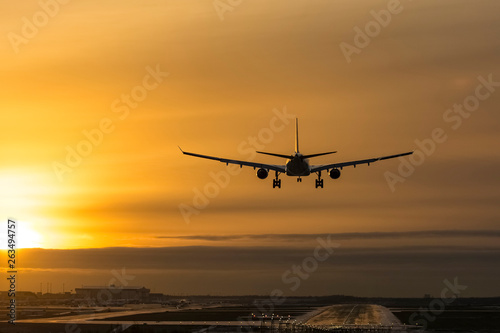 Airplane landing to airport runway in sunset © citikka