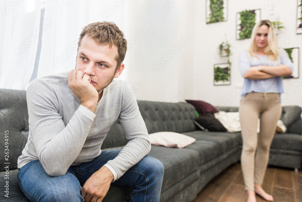 Unhappy young couple quarreling in the living room. Unhappy young couple quarreling in the living room.