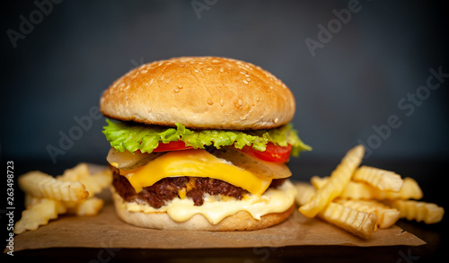  Delicious homemade hamburger with beef, lettuce, cheese, cucumber and french fries on stone background