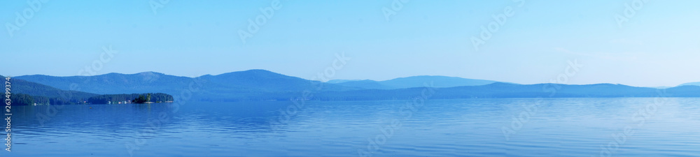 Beautiful blue sky on the lake. Sunset or dawn. White clouds on a blue sky. Natural phenomenon. Suitable for postcards, Wallpapers.