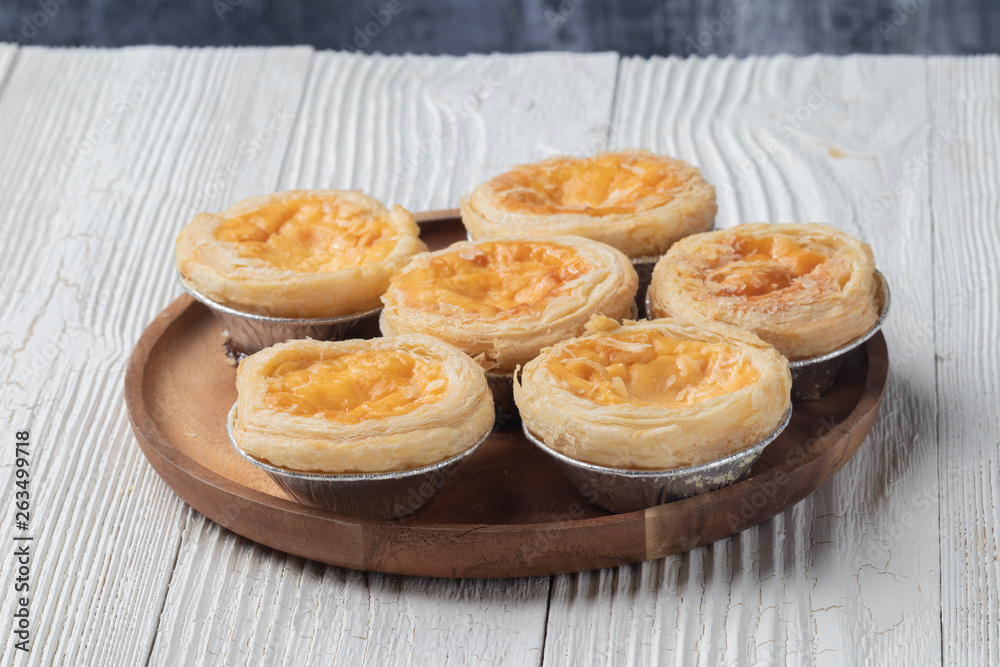 close up of egg tarts on wooden plate close up of egg tarts on wooden plate