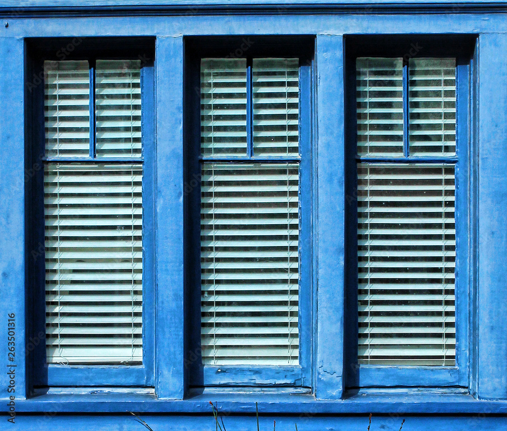 Blue framed window with three vertica panes of glass Blue framed window with three vertica panes of glass
