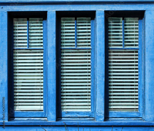 Blue framed window with three vertica panes of glass