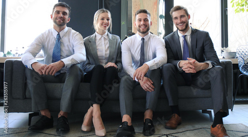 Fotografie Group of four business people sitting on sofa