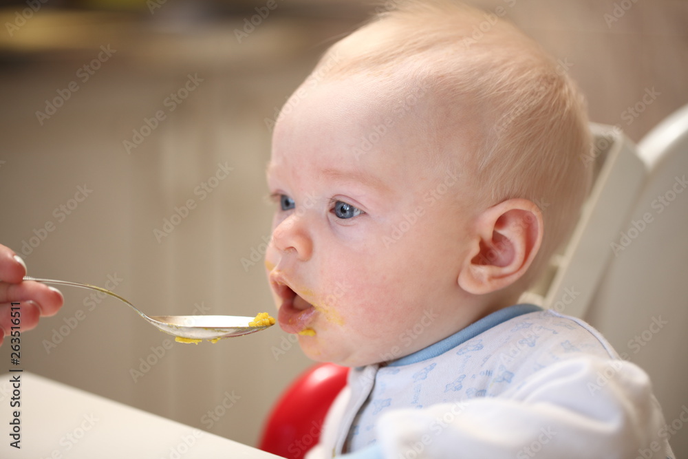 A child of 6 months pedagogical feeding from a spoon of porridge. A child of 6 months pedagogical feeding from a spoon of porridge.