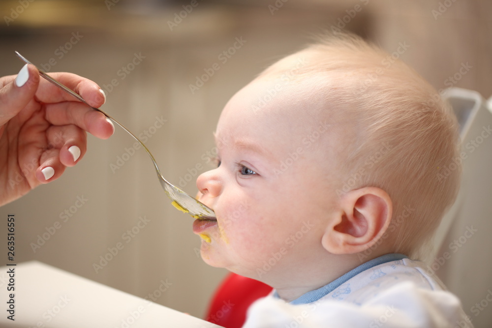 A child of 6 months pedagogical feeding from a spoon of porridge. A child of 6 months pedagogical feeding from a spoon of porridge.